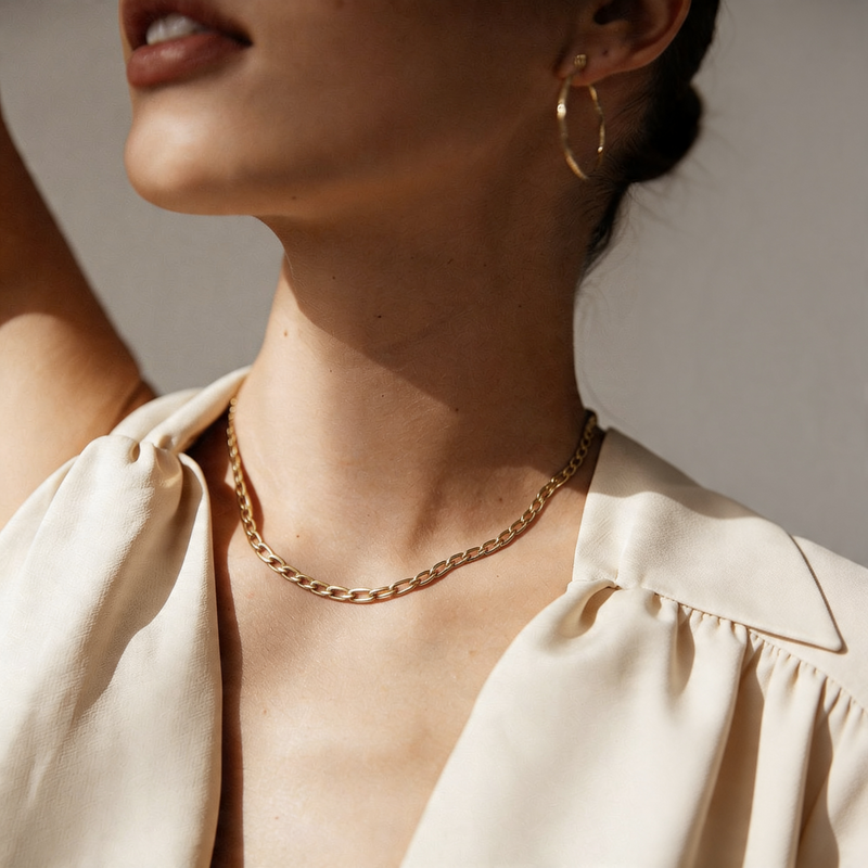 18k gold chain necklace for women on a light pink satin background