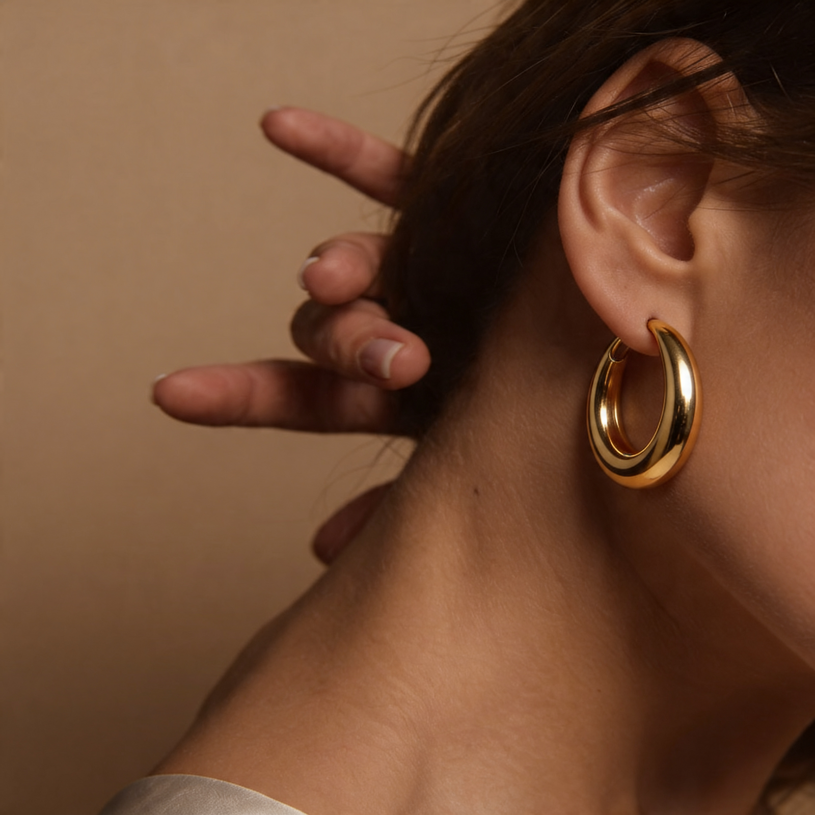 18k gold long chain and pendant earrings on white cloth, geometric design, jewelry closeup