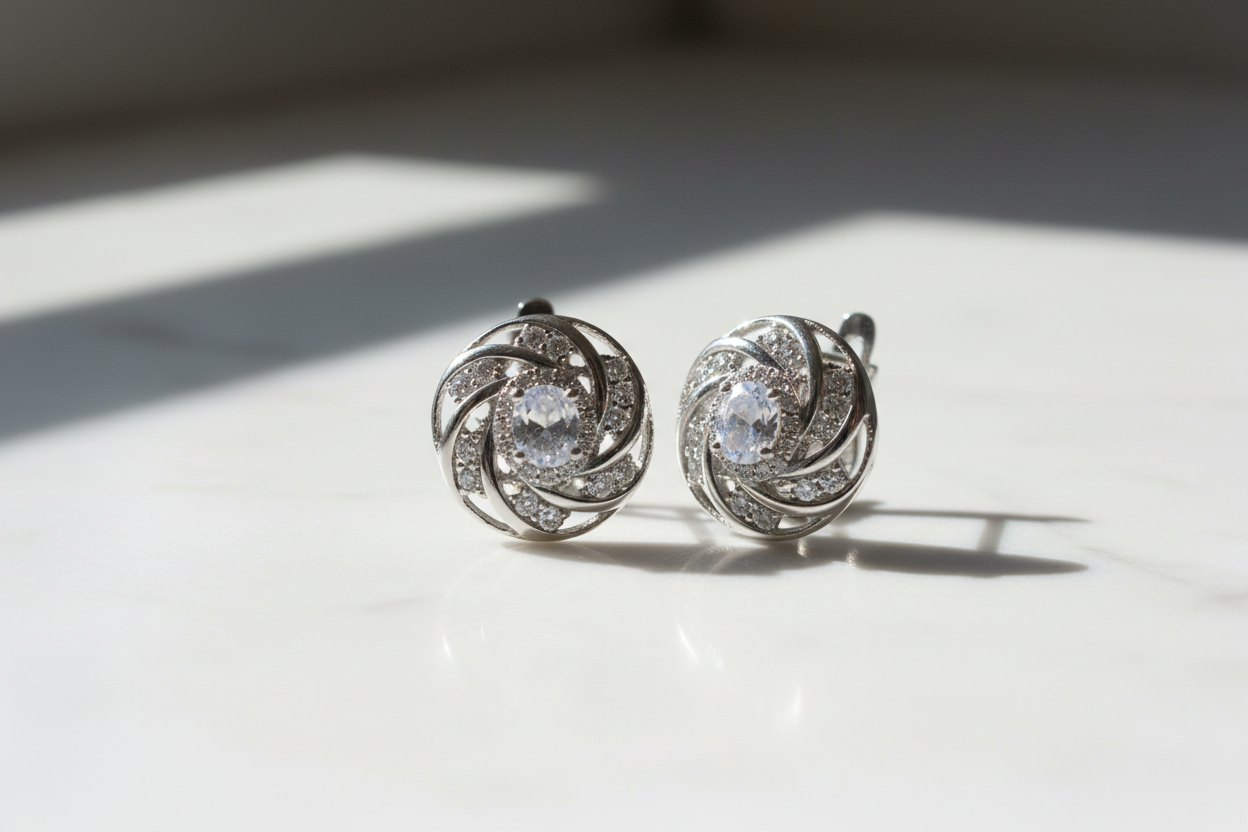 Silver earrings with round diamond accents on a white marble surface