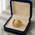 Gold ring with lion head design in a 'Embellish' jewelry box.
