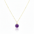 Necklace with a purple bead pendant on a gold chain against a white background