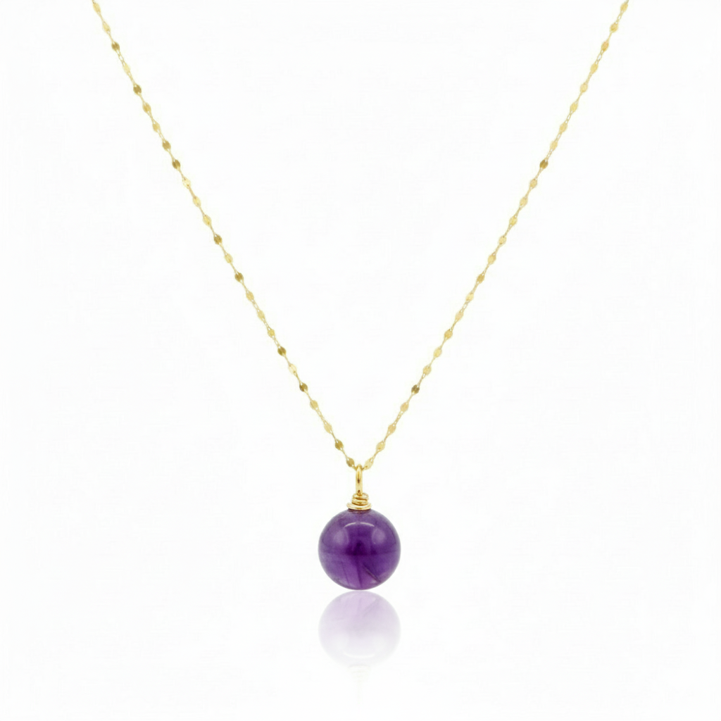 Necklace with a purple bead pendant on a gold chain against a white background