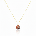 Necklace with a round, multicolored pendant on a thin chain against a white background