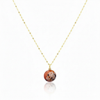 Necklace with a round, multicolored pendant on a thin chain against a white background