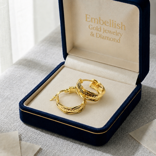 Gold hoop earrings in a 'Embellish Gold Jewelry & Diamond' box on a light surface.