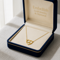 Gold necklace with heart design in an open jewelry box labeled 'Embellish Gold Jewelry & Diamond'.