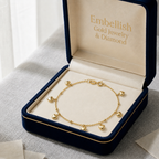 Gold bracelet with heart charms in a 'Embellish Gold Jewelry & Diamond' box.