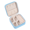 Open jewelry case with compartments on a light gray background