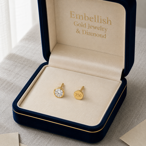 Gold earrings in a 'Embellish Gold Jewelry & Diamond' box on a light surface.