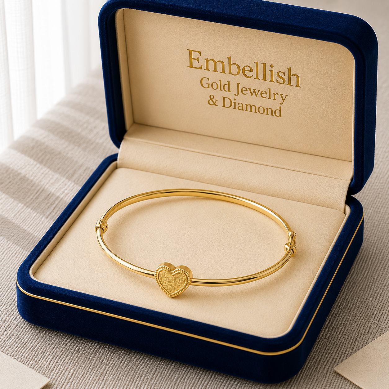 Gold bracelet with heart charm in a 'Embellish Gold Jewelry & Diamond' box.
