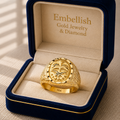 Gold ring in a 'Embellish Gold Jewelry & Diamond' box on a beige surface
