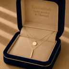 Gold necklace in a 'Embellish Gold Jewelry & Diamond' box on a wooden surface
