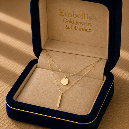 Gold necklace in a 'Embellish Gold Jewelry & Diamond' box on a wooden surface