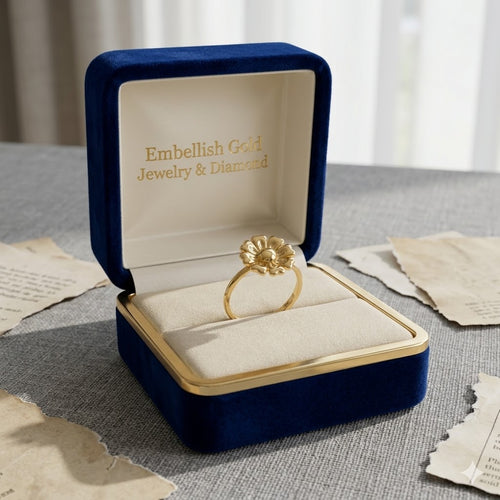 Gold ring in a blue jewelry box with 'Embellish Gold Jewelry & Diamond' text on a textured surface.