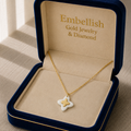 Gold necklace with a star-shaped pendant in an 'Embellish' jewelry box.