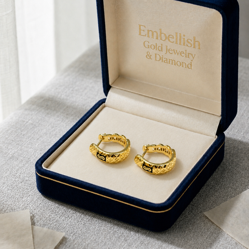 Gold hoop earrings in a 'Embellish Gold Jewelry & Diamond' box on a textured surface.
