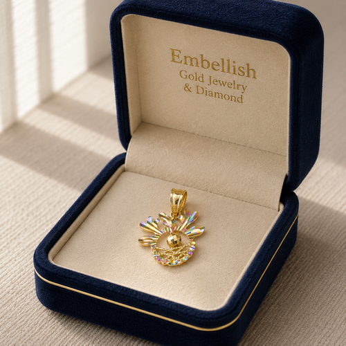 Gold pendant in a 'Embellish Gold Jewelry & Diamond' box on a beige surface.