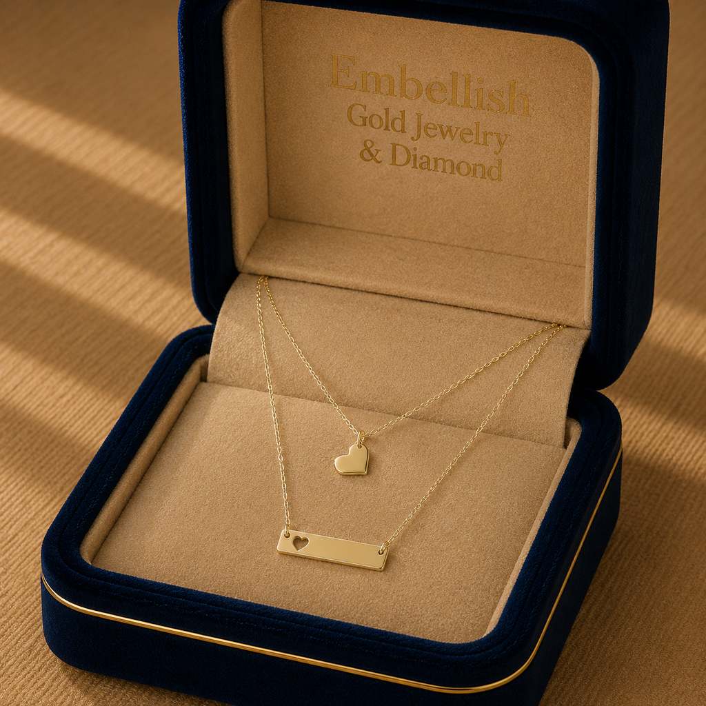 Gold necklace with heart pendants in a 'Embellish Gold Jewelry & Diamond' box.