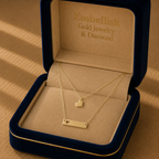 Gold necklace with heart pendants in a 'Embellish Gold Jewelry & Diamond' box.