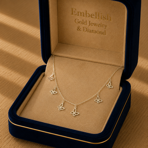 Butterfly necklace in a 'Embellish Gold Jewelry & Diamond' box on a wooden surface