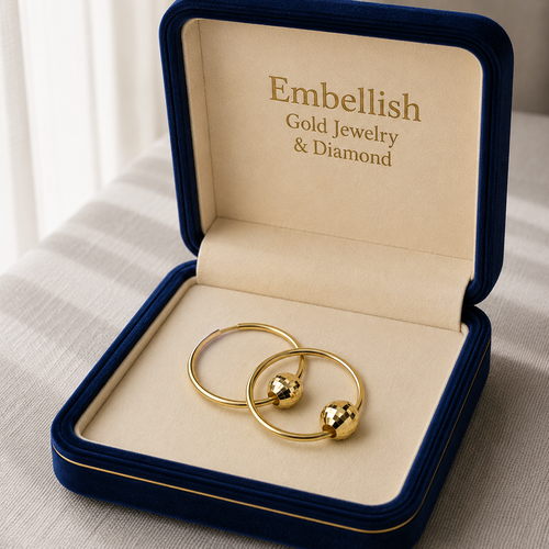 Gold jewelry set in a 'Embellish Gold Jewelry & Diamond' box on a light fabric background