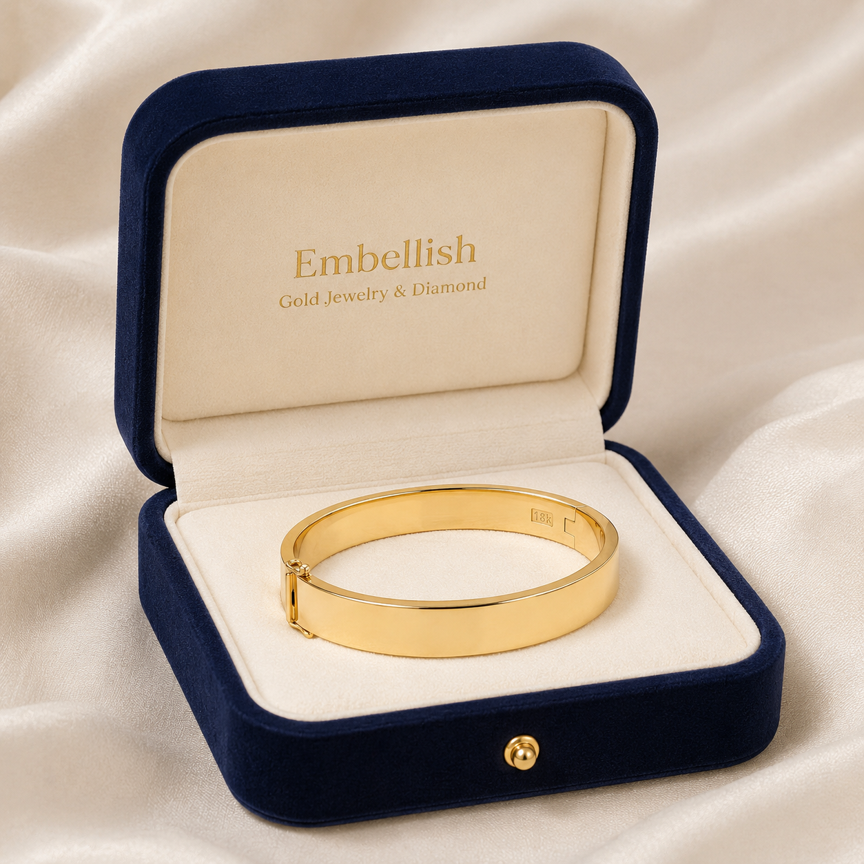 Gold bracelet in an open jewelry box with 'Embellish' branding on a beige fabric background