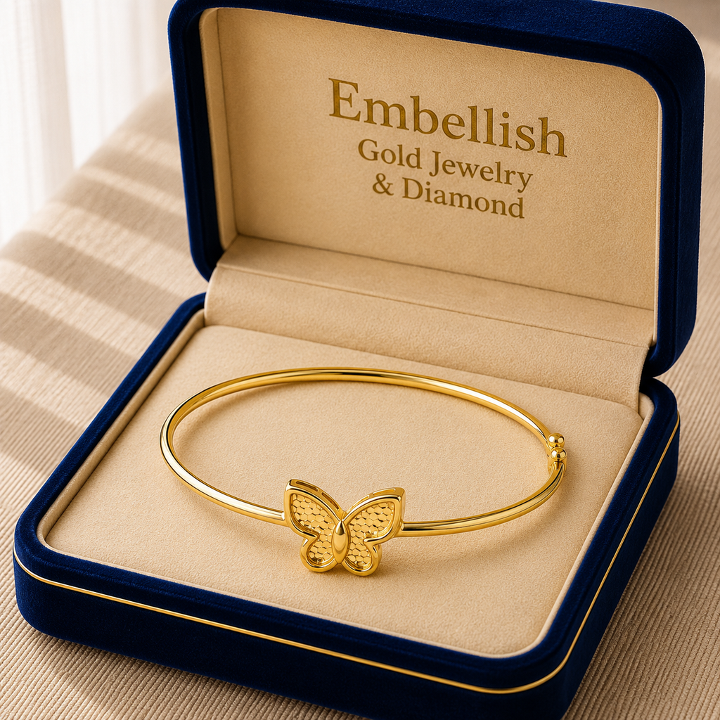 Gold bracelet with butterfly design in a 'Embellish' jewelry box.