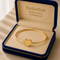 Gold bracelet with heart charm in an 'Embellish' jewelry box.