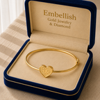 Gold bracelet with heart charm in an 'Embellish' jewelry box.