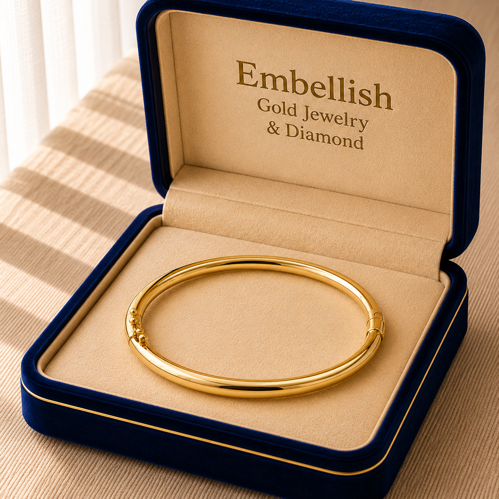 Gold bracelet in a 'Embellish Gold Jewelry & Diamond' box on a striped fabric background