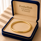 Gold bracelet in a 'Embellish Gold Jewelry & Diamond' box on a striped fabric background