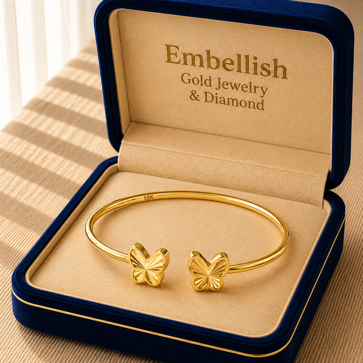 Gold bracelet with butterfly ends in a 'Embellish' jewelry box.