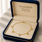 Gold bracelet with heart charms in an open 'Embellish' jewelry box.