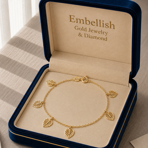 Gold bracelet with leaf charms in an 'Embellish' jewelry box.
