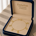Gold bracelet with charms in an 'Embellish' jewelry box