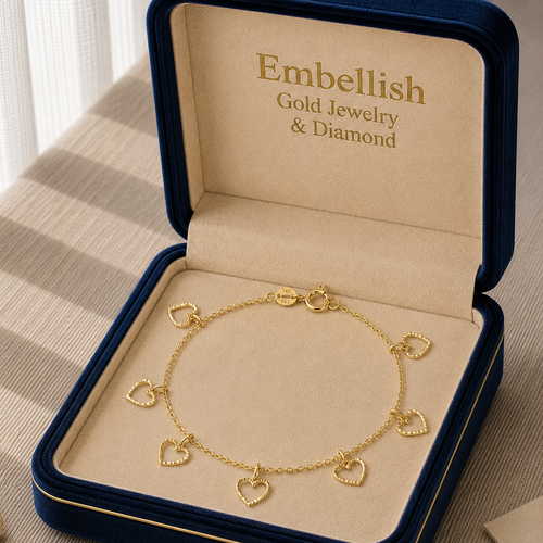 Gold bracelet with heart charms in an 'Embellish' jewelry box.
