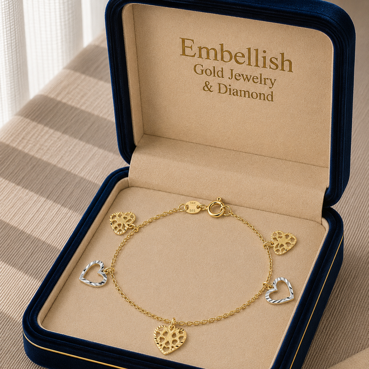 Gold bracelet with heart charms in a 'Embellish Gold Jewelry & Diamond' box.