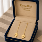Gold ghost-shaped earrings in a 'Embellish Gold Jewelry & Diamond' box.