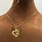 Gold necklace with three interlocking heart pendants on delicate chain, displayed on bust