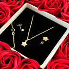 Gold star jewelry set including necklace, earrings, and bracelet in gift box with red roses