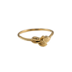Gold ring with a leaf design on a light gray background