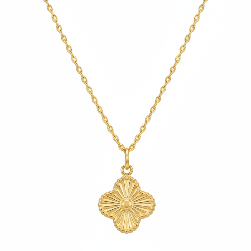 Gold necklace with a clover-shaped pendant on a white background