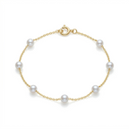 Gold bracelet with pearls on a white background
