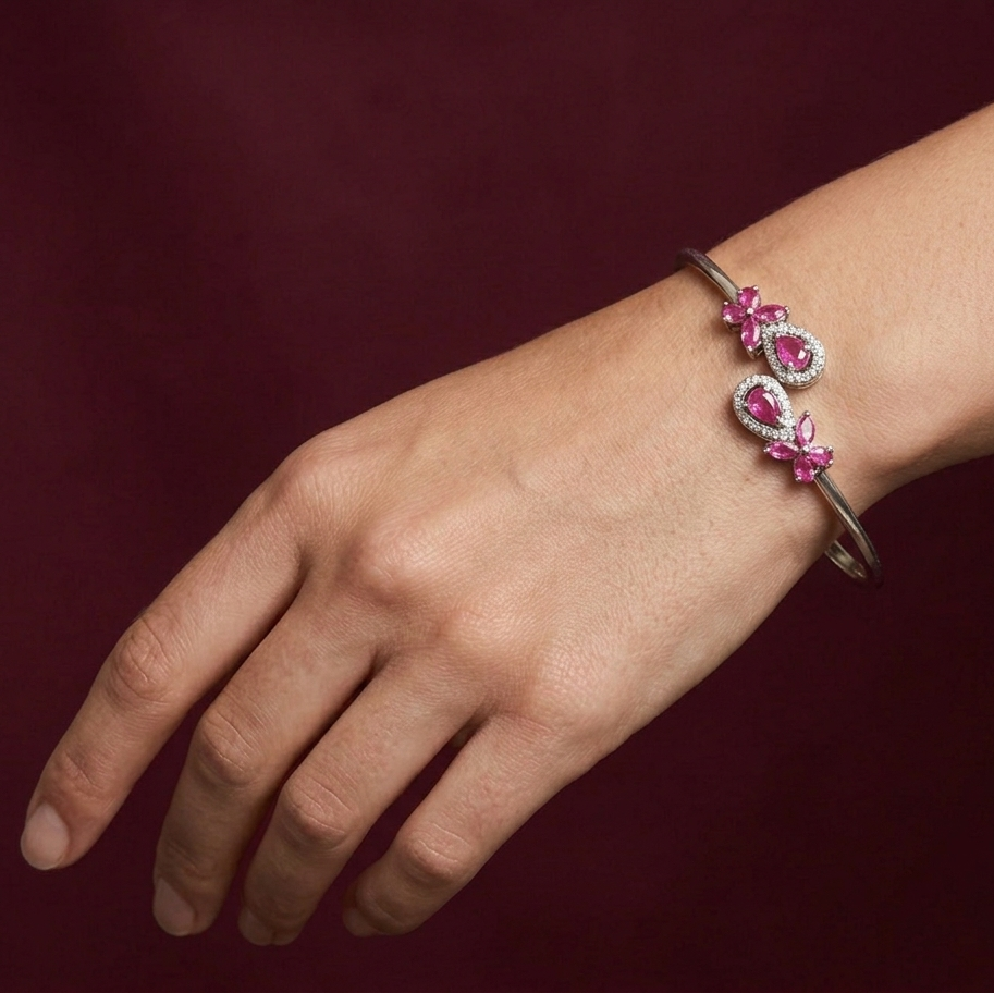 Bracelet with pink gemstones on a wrist against a dark background