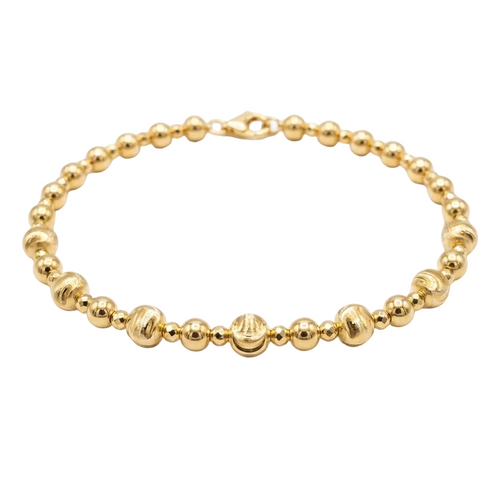 Gold beaded bracelet on a white background