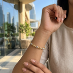 Person wearing a beaded bracelet with a cityscape in the background