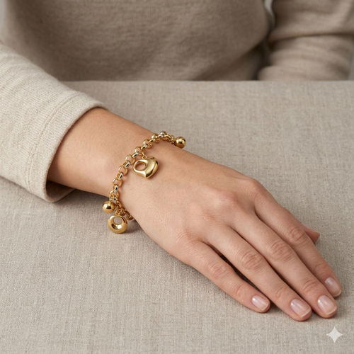 Gold bracelet on a hand against a neutral background