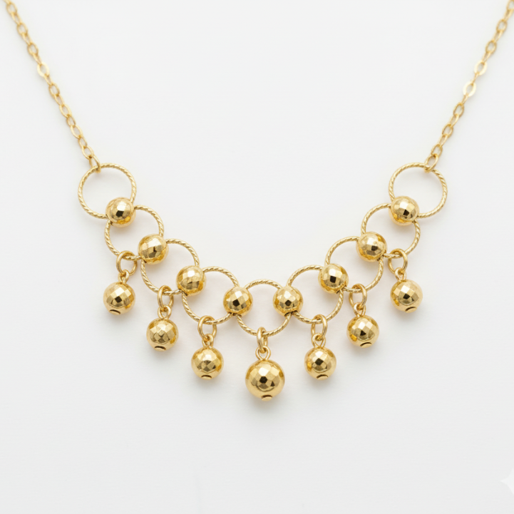 Gold necklace with spherical pendant on a white background