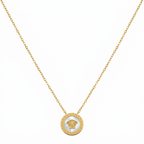 Gold necklace with a Medusa head pendant on a white background