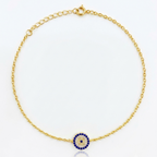 Gold bracelet with a blue and white evil eye charm on a white background